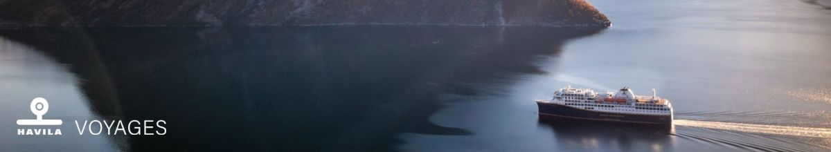 Mit Havila Voyages können Sie durch den Hjørundfjord bei Sonnenschein fahren.