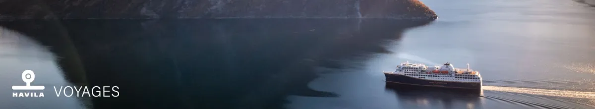 Mit Havila Voyages können Sie durch den Hjørundfjord bei Sonnenschein fahren.