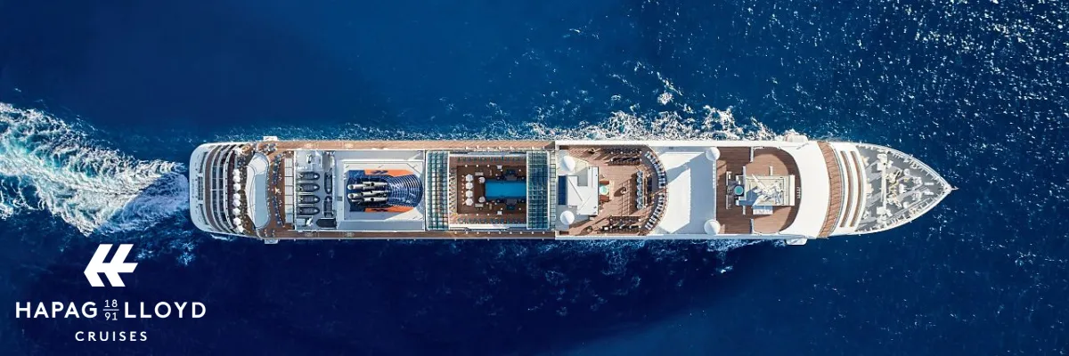 Die MS EUROPA auf dem Meer Luftaufnahme von oben auf das Teakdeck und den Poolbereich eines Hapag-Lloyd Cruises Schiffes im offenen Meer mit Logo unten links.