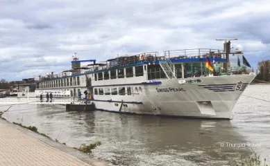 Die MS Swiss Pearl an einem Bootsanleger, Personen verlassen und betreten das Schiff über einen Steg.