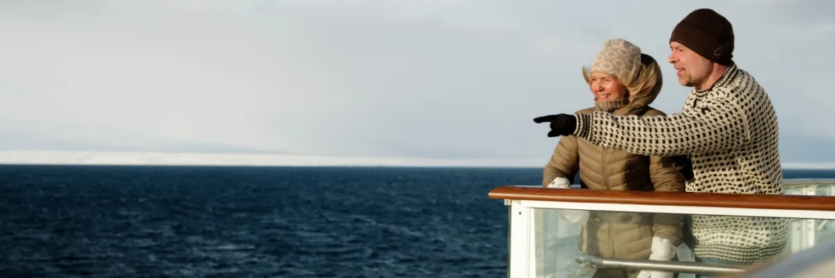 Havila Voyages Aussicht Ein Pärchen an Deck eines Havila Voyages Schiffs genießt die Aussicht auf das offene Meer.