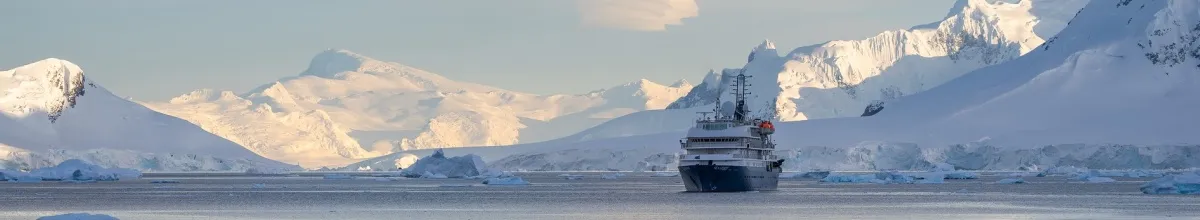Die MS Sea Spirit in der Dämmerung vor gewaltigen Eisformationen im Arktischen Meer.