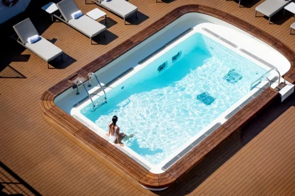 Eine Frau badet alleine im Pool auf einem Schiff der PONANT Explorers.