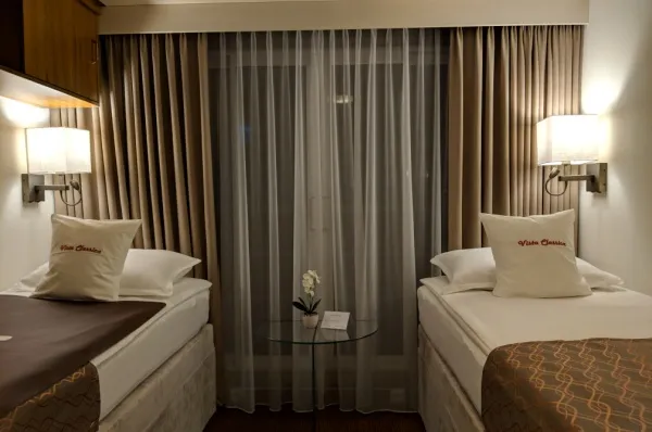 Eine Kabine von VistaClassica mit zwei Betten und Kissen.