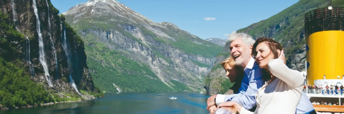 Die Costa Fortuna fährt durch den Geiranger Fjord in Norwegen. an Bord hat sie staunende Gäste auf dem Oberdeck.