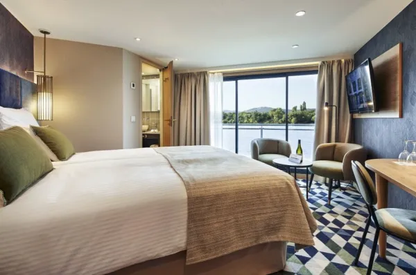 Ein Beispielbild einer Junior Suite auf der MS VIVA RUBY mit Doppelbett und Panoramafenster.