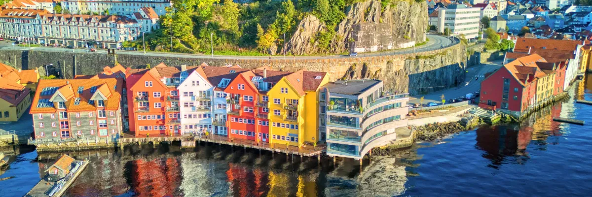 Malerische, farbenfrohe Holzhäuser an der Kaikante in Bergen, Norwegen, bei strahlendem Sonnenschein während eines Landausflugs.