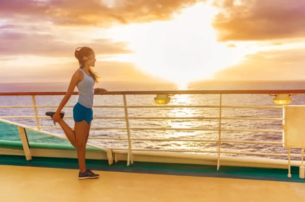 Eine Frau trainiert auf dem Deck während Sonnenuntergang.