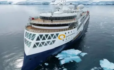 Die Ocean Explorer, ein Schiff der Quark Expeditions Flotte, in einem Eismeer von vorne fotografiert.