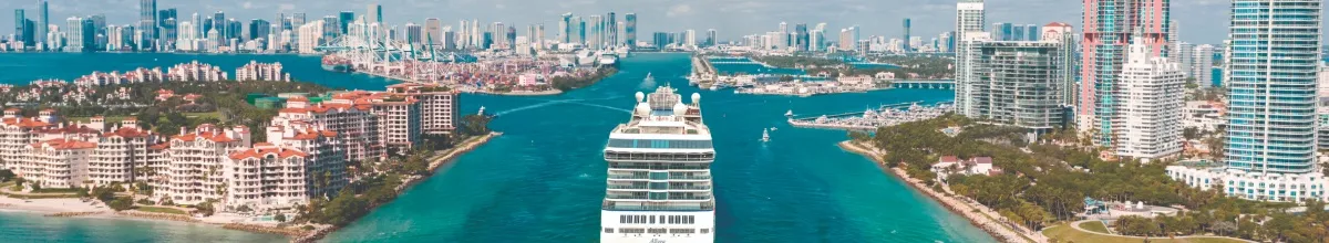 Die MS Allure fährt im sonnigen Hafen von Miami ein und wird von Hochhäusern und türkisem Wasser eingerahmt.