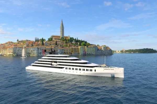 Die Emerald Kaia der Reederei Emerald Cruises voor einer mediteranen Küstenstadt im Meer.
