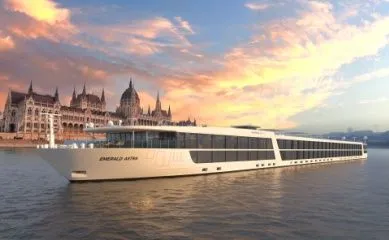 Ein Rendering der Emerald Astra auf der Donau vor dem Parlament von Budapest im Sonnenuntergang.