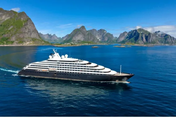 Hochseeyacht Scenic Eclipse vor Berglandschaften im blauen Wasser.