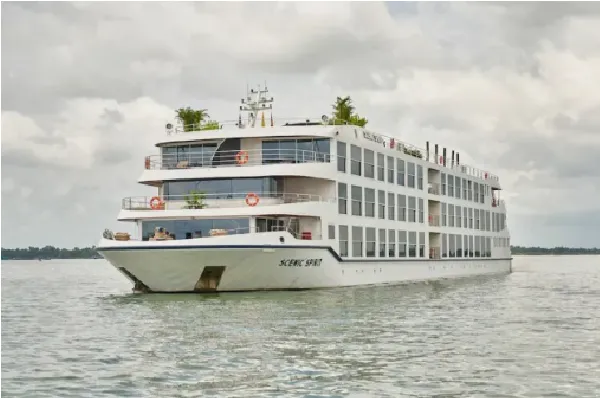 Die Scenic Spirit schippert über den Mekong unter bewölktem Himmel.