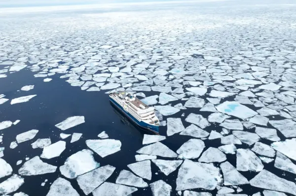 Die Swan Hellenic Schiffe Die SH Vega zwischen Eisschollen im tiefblauen, Arktischen Meer aus der Luft fotografiert. Copyright: Swan Hellenic