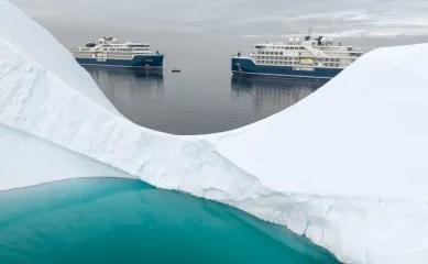 Die SH Diana und SH Vega zusammen in einem Eismeer. Im Vordergrund befindet sich ein Gletscher mit einem See auf dem Eis.