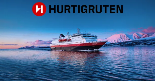 Ein klassisches Postschiff von Hurtigruten Das Original navigiert durch ruhige, tiefblaue Gewässer vor einer Kulisse aus schneebedeckten norwegischen Bergen im rosa Abendlicht der Dämmerung.