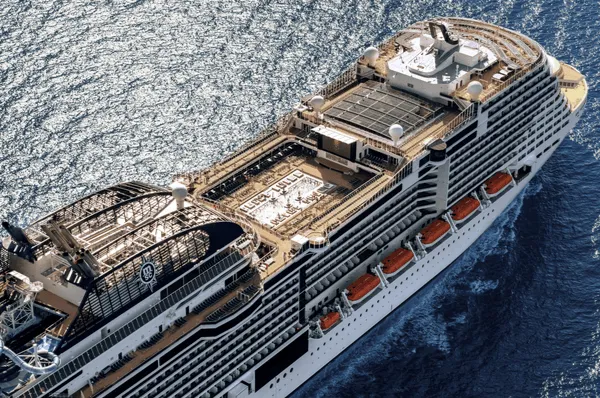 Das moderne Kreuzfahrtschiff von MSC Cruises auf einer traumhaften Reise über das Meer bei leichtem Wellengang und Sonnenschein.