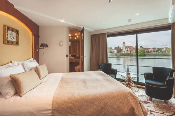 Suite mit Doppelbett und französischem Balkon plus zwei Sesseln.