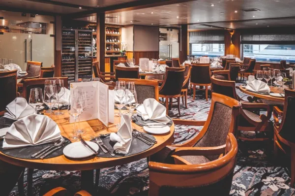 MS Swiss Pearl Gastronomie Restaurant mit gedeckten runden Tischen an Bord der MS Swiss Pearl.