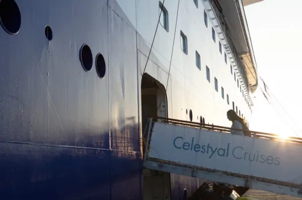 Der Aufstieg in die Celestyal Discovery im Sonnenuntergang. Auf der Rampe steht "Celestyal Cruises".