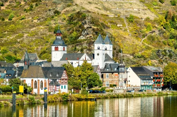 Schönsten Routen mit DCS Touristik entdecken Rheinroute mit DCS-Touristik: eine Stadt mit Bergen im Hintergrund.