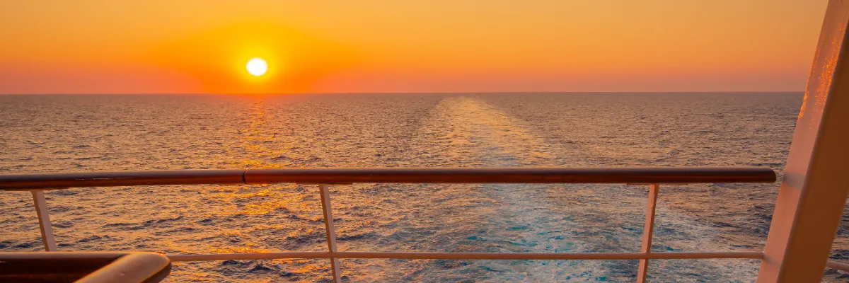 Sehnsucht Pur: Ihr Blick auf das weite Meer mit AIDA im Sommer 2028 Der Blick vom Heck eines AIDA Schiffes auf das schäumende Kielwasser im glitzernden Licht der untergehenden Sonne. Die goldene Abendsonne steht tief über dem Horizont und erzeugt eine friedliche, maritime Atmosphäre auf hoher See.
