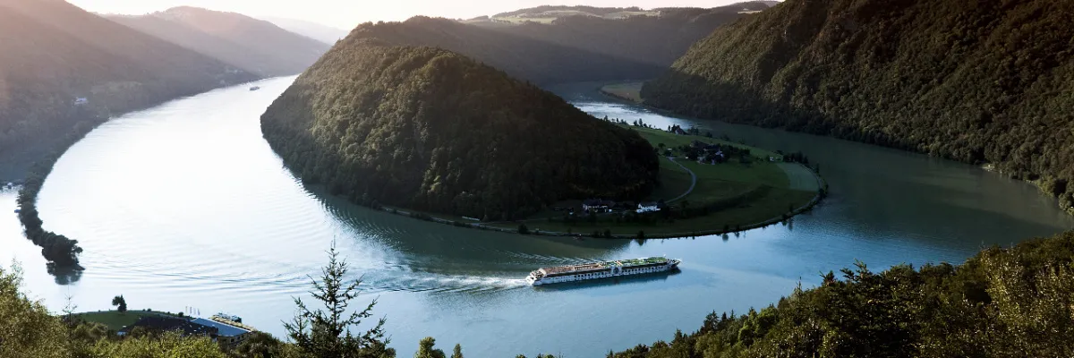 Ein A-ROSA Schiff navigiert im warmen Abendlicht durch die malerische Schlögener Schlinge auf der Donau während des Oster-Specials.