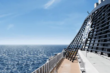 Blick vom Außendeck eines MSC Kreuzfahrtschiffes auf das offene Meer, mit dem markanten Schornstein mit MSC-Logo. Die Szene steht für das Kreuzfahrterlebnis an Bord, das durch die verschiedenen MSC Erlebniswelten gestaltet wird.