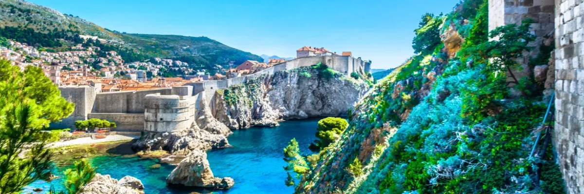 Blick auf die historische Stadtmauer von Dubrovnik und das kristallklare Adriatische Meer – ein Highlight vieler AIDA-Routen.