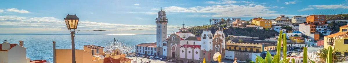 Panoramaaufnahme der Basilika von Candelaria auf Teneriffa unter strahlend blauem Himmel mit Blick auf den glitzernden Atlantik – ein Sinnbild für die sonnigen Landgänge während einer Kanaren-Kreuzfahrt.