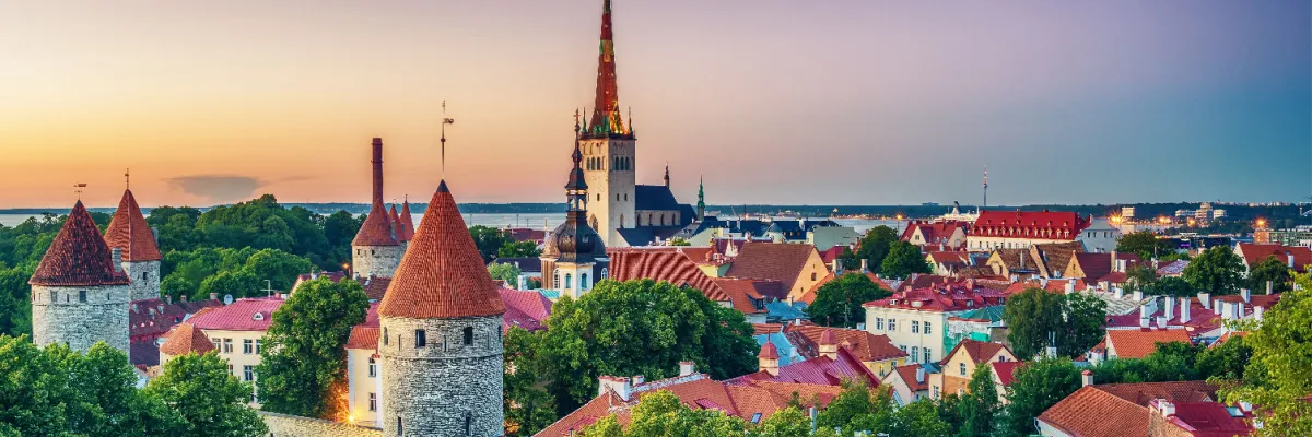 Panorama der historischen Altstadt von Tallinn mit ihren charakteristischen roten Ziegeldächern und spitzen Kirchtürmen während einer goldenen Abenddämmerung – ein kultureller Höhepunkt auf den Nordeuropa-Reisen mit AIDAprima.