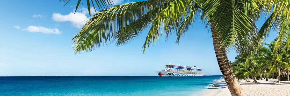 Ein AIDA Kreuzfahrtschiff an einer tropischen Küste mit Palmen und weißem Sandstrand – Aktion für die gratis Internet-Flat 2026.