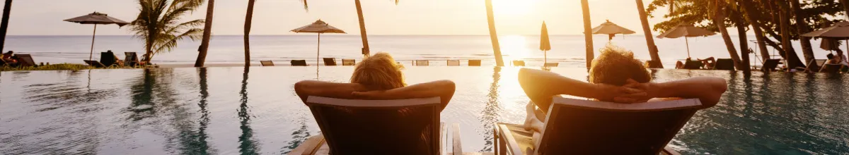 Gäste entspannen auf Sonnenliegen am Pool eines Kreuzfahrtschiffs bei Sonnenuntergang – Kreuzfahrt-Knigge 2026.