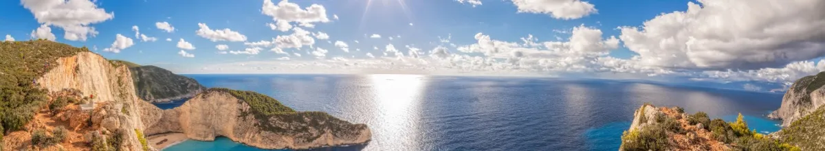 Blick über die Küste von Zakynthos mit dem blauen Himmel mit Wolken im Hintergrund.