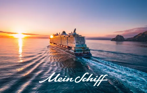 Seien Sie bei der Taufe von Mein Schiff Flow live dabei Heckansicht von Mein Schiff Flow auf dem Meer auf der Fahrt Richtung Sonnenuntergang.