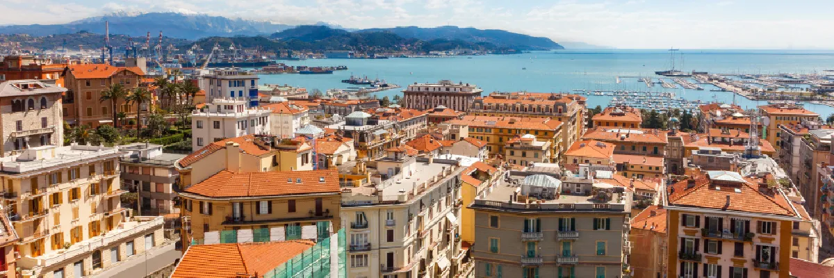 Blick über eine malerische Hafenstadt am Mittelmeer mit Bergen im Hintergrund – authentische Landgänge und Kultur im Winter 2026/27 mit der Mein Schiff Flow entdecken.