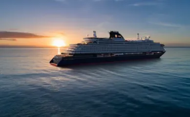 Die EXPLORA V von Explora Journeys fährt auf hoher See dem Sonnenuntergang entgegen.