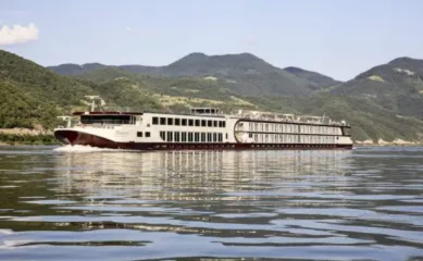 Die MS Nestoy von GTA TOURISTIK auf dem Rhein an einem schönen Sommertag mit Bergen im Hintergrund.