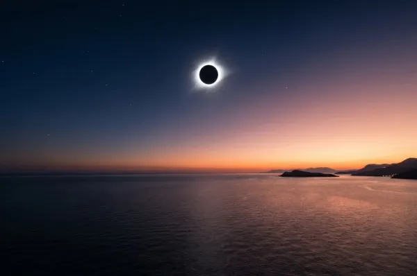 Totale Sonnenfinsternis 2027 über dem Mittelmeer Totale Sonnenfinsternis 2027 über dem Mittelmeer, schwarze Sonne mit silbriger Korona am verdunkelten Himmel.