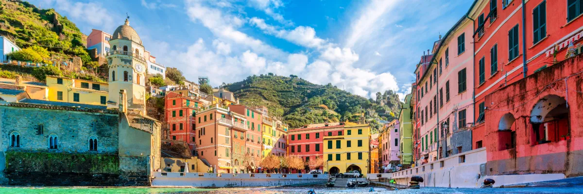 Malerische, bunte Häuserfassaden und der markante Kirchturm im idyllischen Hafen von Vernazza an der ligurischen Küste in Italien.