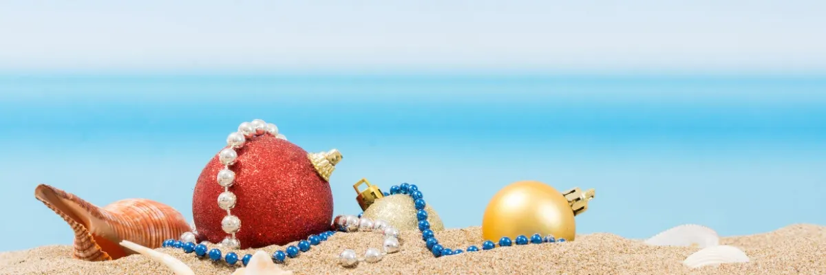 Jetzt Weihnachts- und Silvesterkreuzfahrten mit 100 € Rabatt sichern Rote und goldene Weihnachtskugeln am Strand