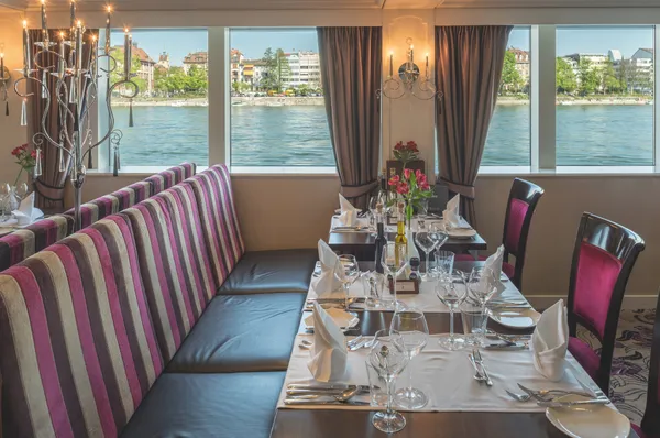 Gedeckte Tische im Restaurant der MS Antonio Bellucci mit Blick auf den Fluss.