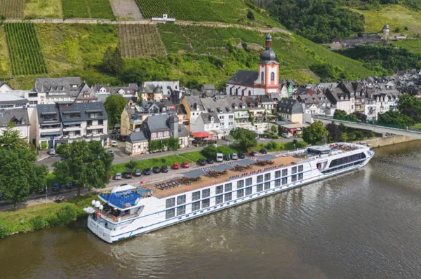 Die MS Antonio Bellucci liegt vor einem Weinort mit steilen Weinbergen am Flussufer.