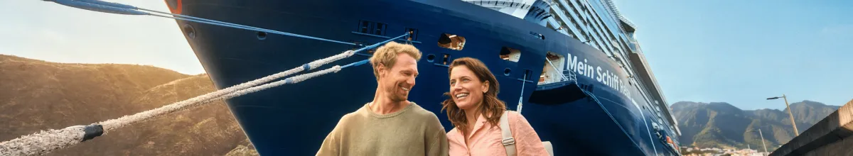 Die imposante Mein Schiff Relax Ein glückliches Pärchen vor der Mein Schiff Relax.