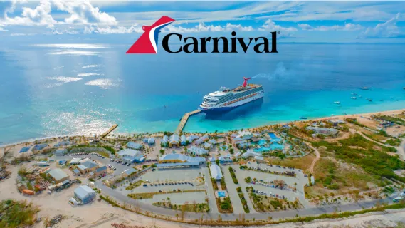 Ein Carnival Cruise Line Kreuzfahrtschiff liegt am Pier einer paradiesischen Karibikinsel im türkisblauen Meer unter blauem Himmel.