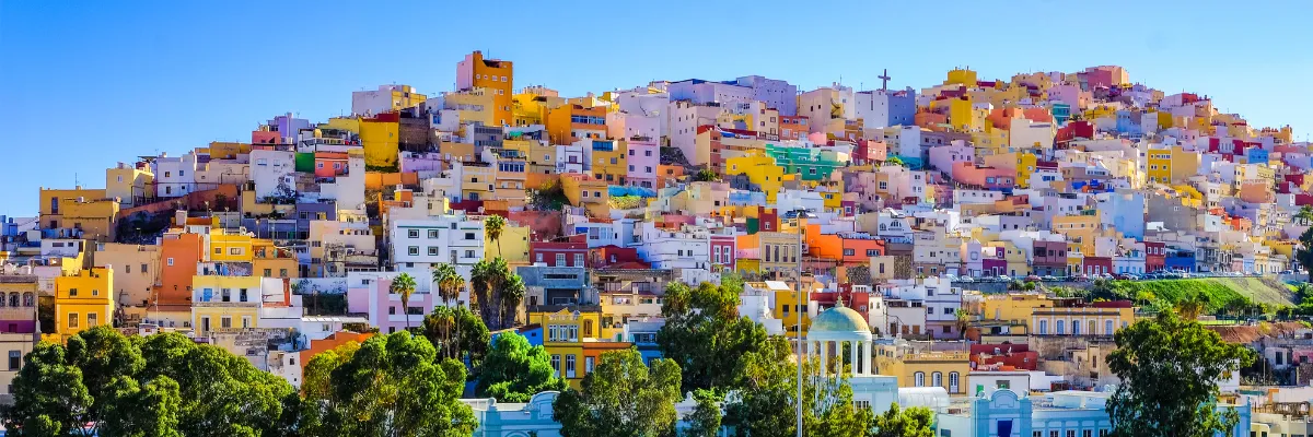 Kanaren Costa Kreuzfahrt Winter 2026 2027 Gran Canarias bunte Häuser auf einem Hügel bei sommerlichem Wetter.