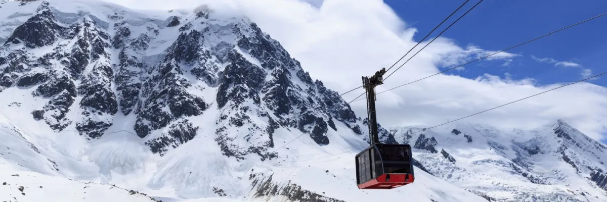 Kreuzfahrt zu dem Ski-Festival in Oslo buchen Eine Skiliftkabine mitten in den Bergen, die vollständig mit Schnee bedeckt sind.