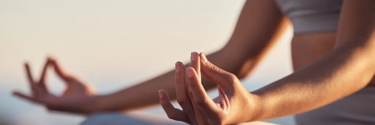 Body & Soul Kreuzfahrt entdecken Eine Frau meditiert, wobei ihre Hände im Fokus stehen.