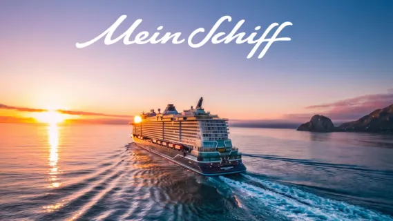 Heckansicht von Mein Schiff Flow im Sonnenuntergang. Rechts ist eine große Felsformation zu sehen. Oben der Mein Schiff Schriftzug in blau.